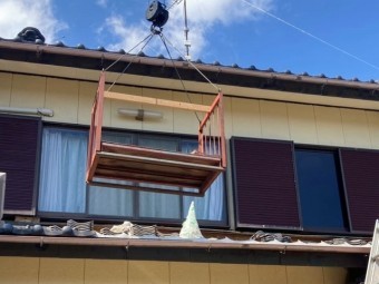 ユニックに鉄籠を吊るし、揚げ降ろしを行っている風景