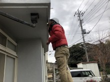 ベランダ下軒天をライトで奥まで確認する職人
