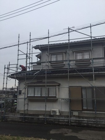 下屋部分の乗り足場を組み立てる作業員