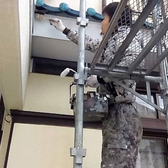 木部に木部専用下塗り材を塗布する職人