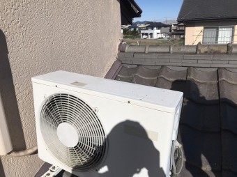 屋根瓦の上に設置されているエアコンの室外機