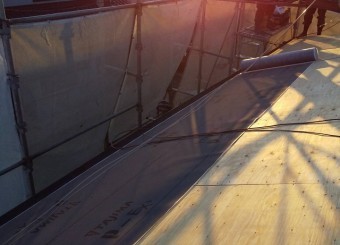 野地板の上に改質アスファルトルーフィングを敷き込んでいく