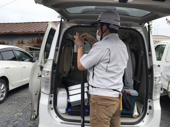 ビーロッド製の高所棒にカメラを取り付けるスタッフ