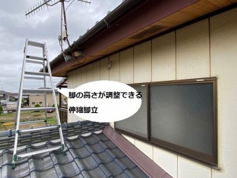 伸縮脚立を下屋根の棟にまたがせて掛ける