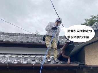 散水調査を行うために屋根上にホースを伸ばす調査スタッフ