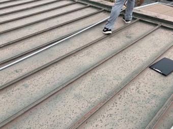 瓦棒ぶき屋根をスケールで計測する職人