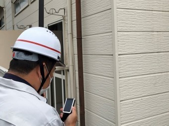 屋根の状態を手元カメラで確認する作業員
