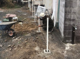 フェンス台を設置し、支柱を設置する職人