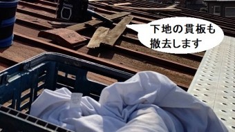 瓦棒屋根の棟木を解体する職人