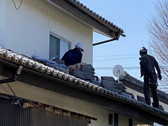 下屋根にて作業する職人