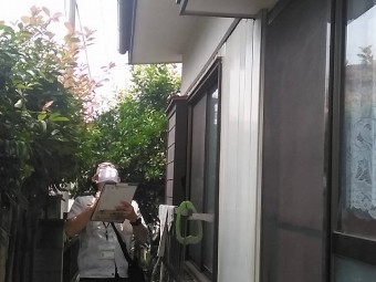 チェックリストを元に雨樋から漏れが無いかを確認するスタッフ