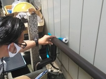 雨樋のジョイント部分に緩みが無いか確認する作業員