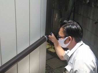 雨樋に緩みが無いかを確認するスタッフ