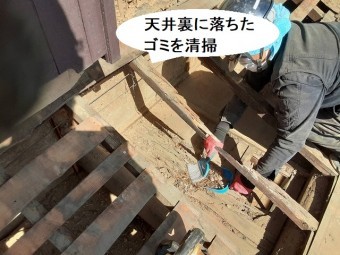 天井裏に落ちたゴミを清掃するスタッフ