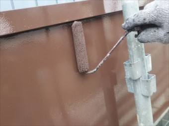 板金にローラーで塗布する職人