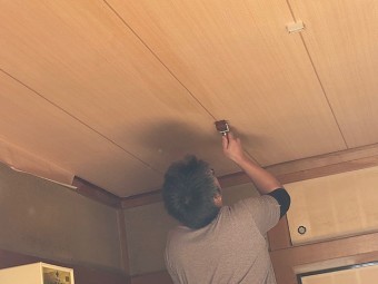 専用ローラーで天井壁紙を仕上げる職人