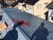 屋根に荷物を揚げる職人