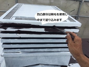 煙突の凹凸部に刷毛で塗り込む職人