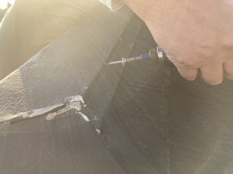 棟板金にステンレススクリュービスを打ち込むスタッフ