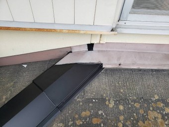 交換した棟板金と既存の壁際水切り板金の接合部