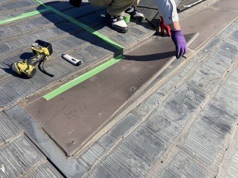 どぶ溝を塞いでいる鉄板を外すスタッフ