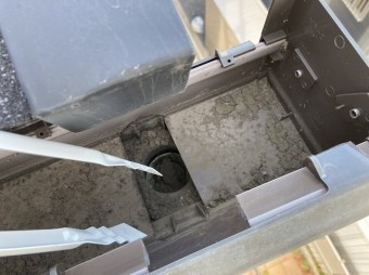 集水器に詰まっている障害物を、火ばさみで引っ張り出す