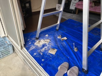 天井材の穴開け時に養生したブルーシートに落ちた石膏ボードの破片