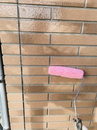 日立市の塗装現場でサイディングにローラーでUVクリアー塗料を塗布