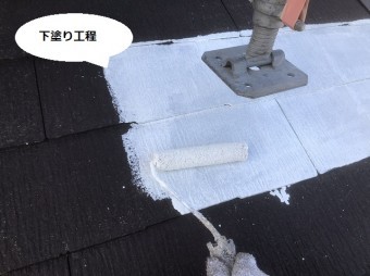 足場の脚を廻しあげて隙間に下塗り塗料を塗布