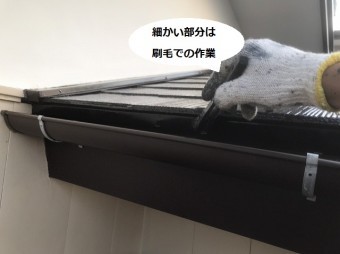 刷毛で軒先の細かい部分を塗装する職人