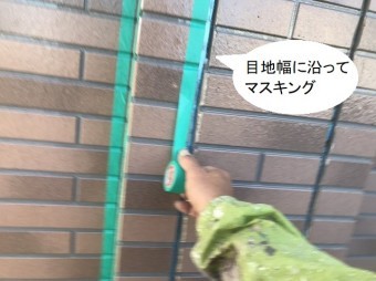 サイディングの目地に沿ってマスキングテープを貼る職人
