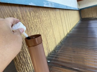 竪樋の継手の内側に接着剤を塗布する担当者