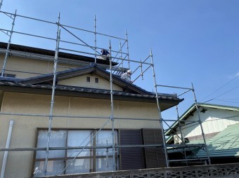 結城市の一文字瓦屋根の上で採寸する職人