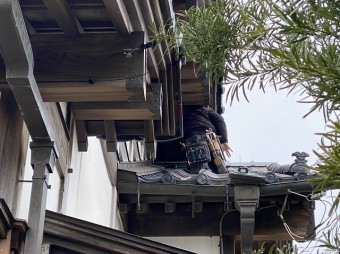 妻側の屋根に慎重に乗る職人