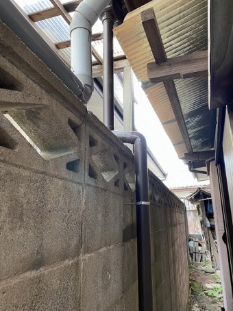 1階の集水器から落ちる竪樋をブロック塀伝いに施工