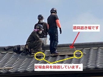 足場金具を設置し工程を確認しあう職人達