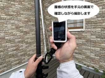 屋根の状態を手元画面で確認する店長