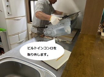 ビルトインコンロを撤去する為本体を持ち上げる職人