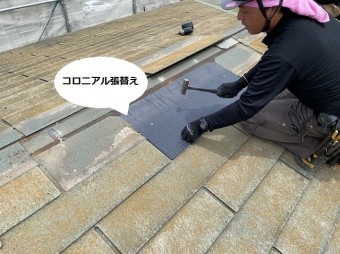 棟際に新しいコロニアルを葺く職人