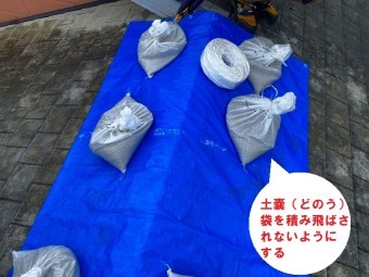 日立市のスレート屋根雨漏り調査で屋根上から判明した雨漏り箇所でブルーシートに土嚢を載せ応急処置