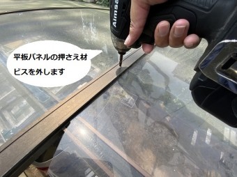 平板パネルの押さえ材をインパクトドライバーで外している職人の手元