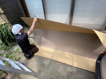 カッターで包装を開口している職人