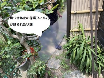 傷つき防止用フィルムが貼られた状態のパネルを運ぶスタッフ