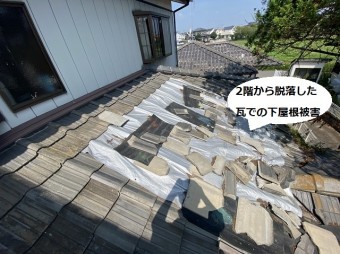 2階から脱落した瓦で二次破損した下屋根をシートで被う