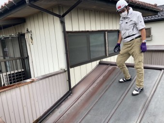 小美玉市のパラペット屋根に登る調査員