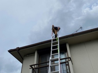 水戸市のスレート屋根に二連梯子で登るところ