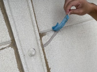 上側のマスキングテープを剥がす作業員