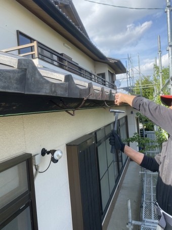 いぶし雨樋用支持金具を鼻隠しに施工する職人