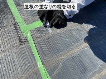 スレート屋根の重なりの縁を切るスタッフ