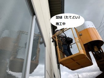 高所作業車で竪樋を施工するスタッフ